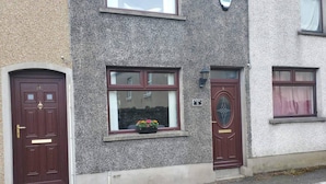 A two-story building with a stone facade, numbered doors, and a window with a flower box. - Minimum Stay two Nights (Larne)