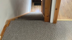A staircase with carpeted steps leading to a door with a circular window. - Minimum Stay two Nights (Larne)