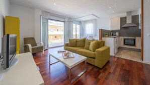 Uma sala de estar moderna com um sofá, uma mesa de centro e uma televisão.