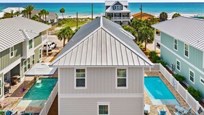 A residential property with a swimming pool, a fenced deck, and a view of the ocean.