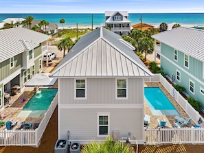 A residential property with a swimming pool, a fenced deck, and a view of the ocean.