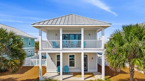 A two-story house with a covered porch and a fenced yard.