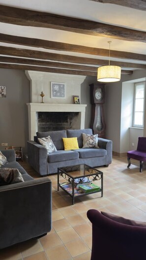 A living room with a fireplace, a sofa, a coffee table, and a clock.