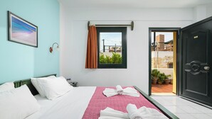 Una habitación de hotel con cama, ventana y puerta.