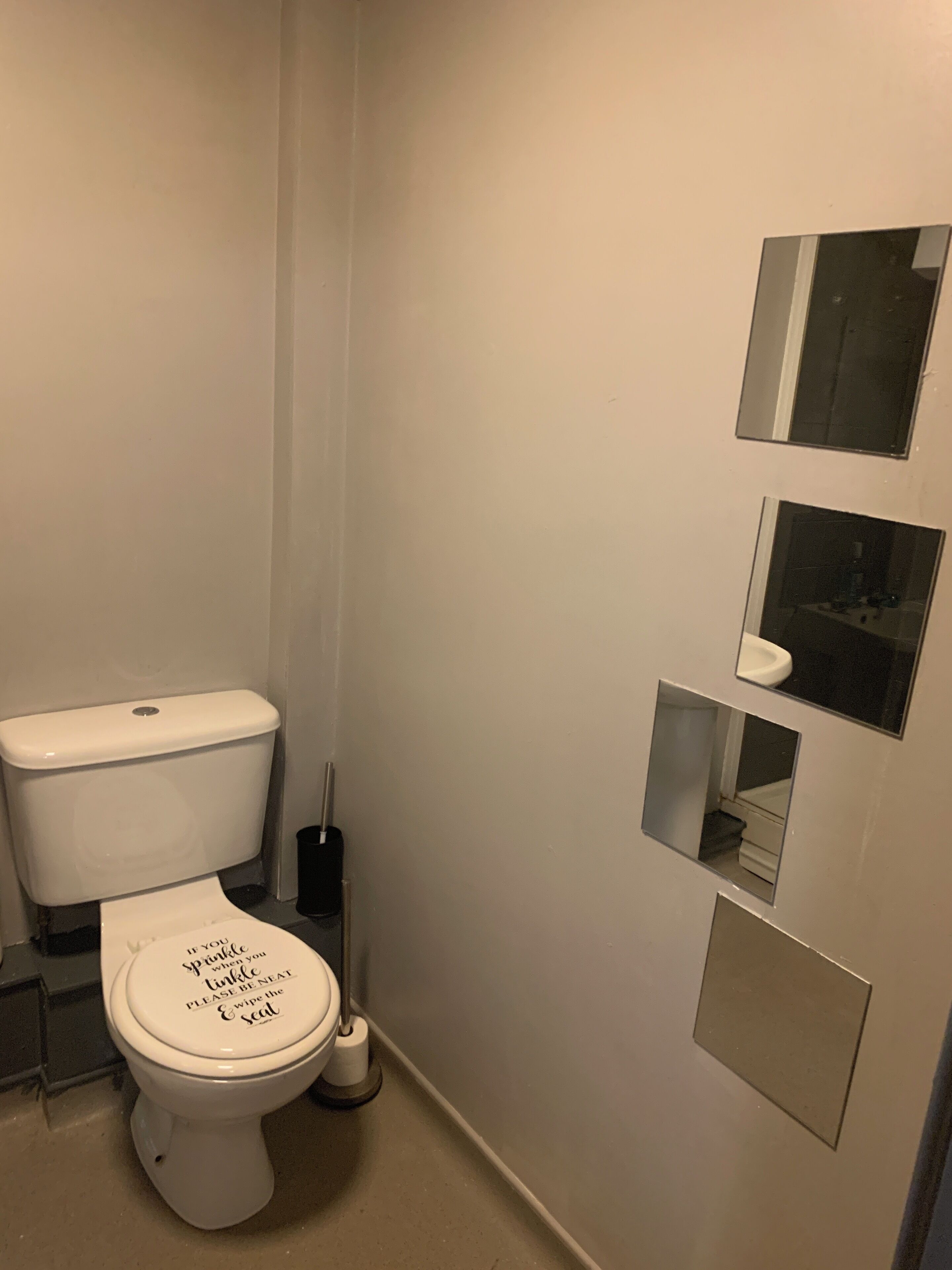 A small, compact bathroom with a toilet, a bidet, and a mirror.