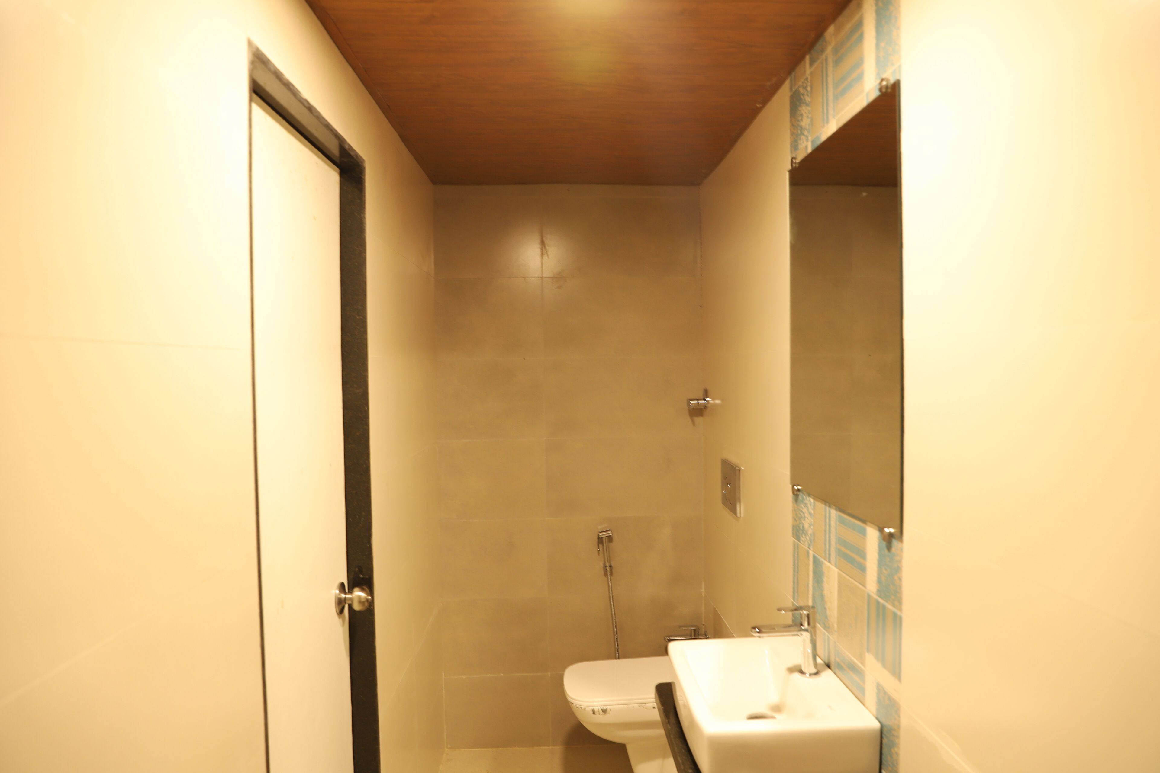 A small, narrow bathroom with a toilet, sink, and shower.
