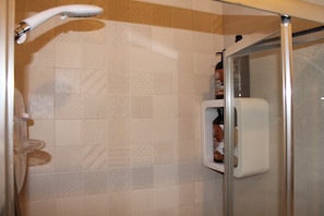 A shower area with a glass door, a handheld showerhead, and a soap dispenser on the wall. - Stunning 4-bed House in Belfast (Belfast)