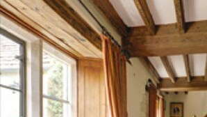 A room with wooden beams, a window with a view, a bench with cushions, and a small table with a lamp. - Charming cottage in the heart of the Cotswolds (Cirencester)