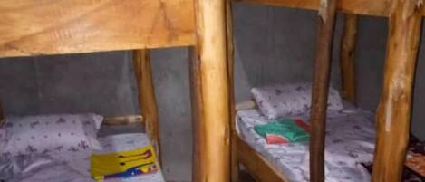 A bunk bed room with wooden frames and a concrete floor.