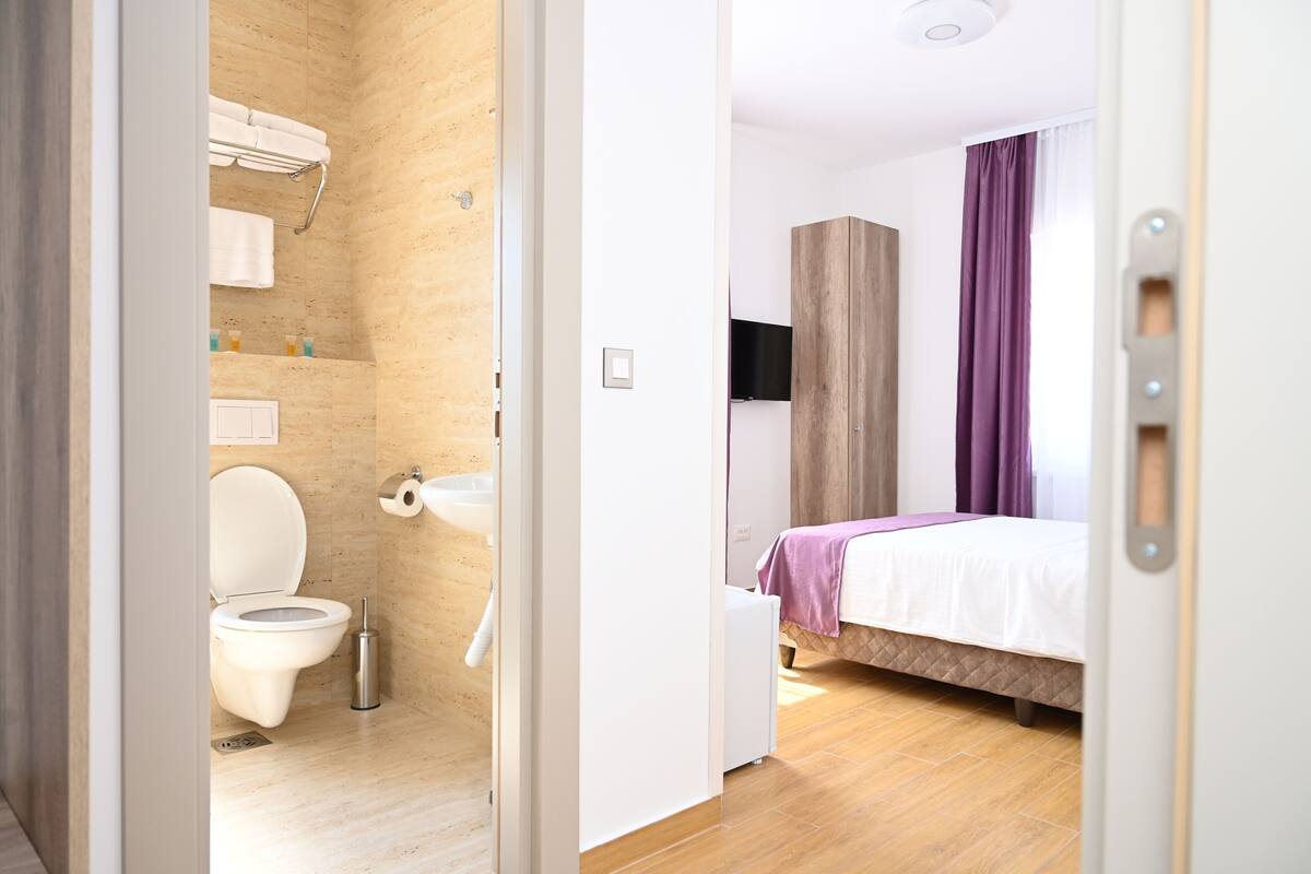 A modern bathroom with a toilet, sink, and towel rack.