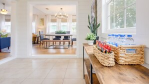 A spacious kitchen with a dining area, wooden flooring, and large windows.