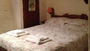 Quarto com cama, porta e quadro fixado na parede.