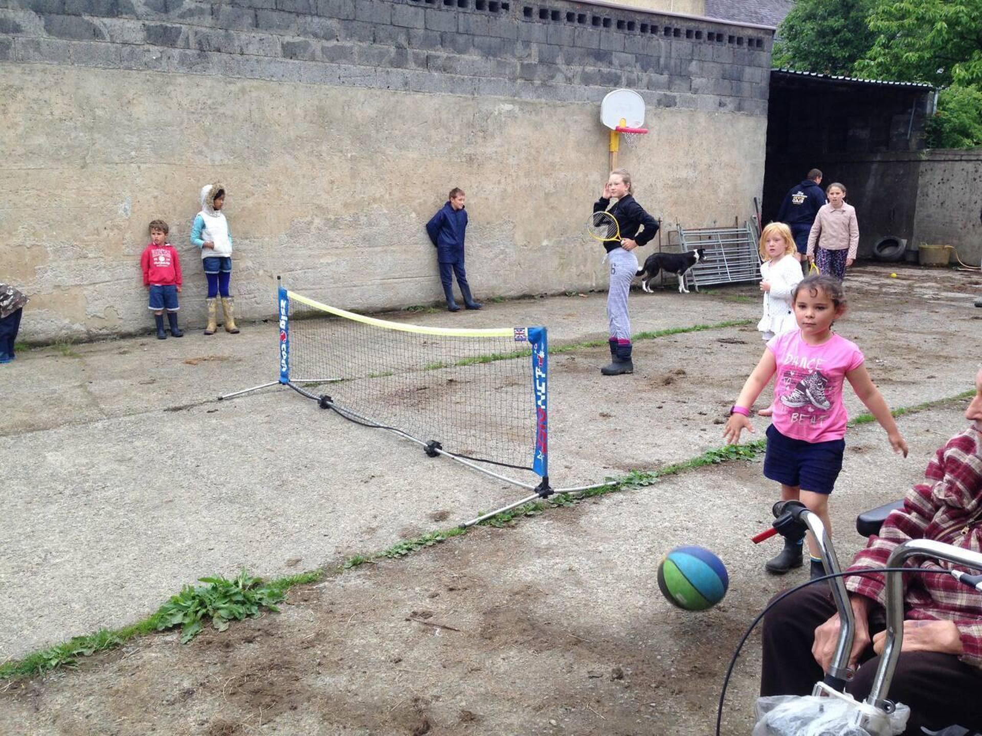 Un grupo de personas jugando con una pelota cerca de una red improvisada.
