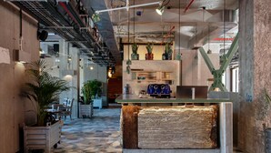 A modern interior with a central island, potted plants, and a patterned floor. - Jam Hotel Lisbon (Lisbon)