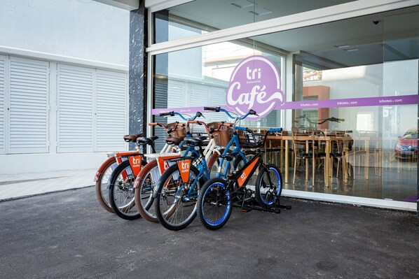 Un café con escaparate de vidrio y bicicletas estacionadas afuera.
