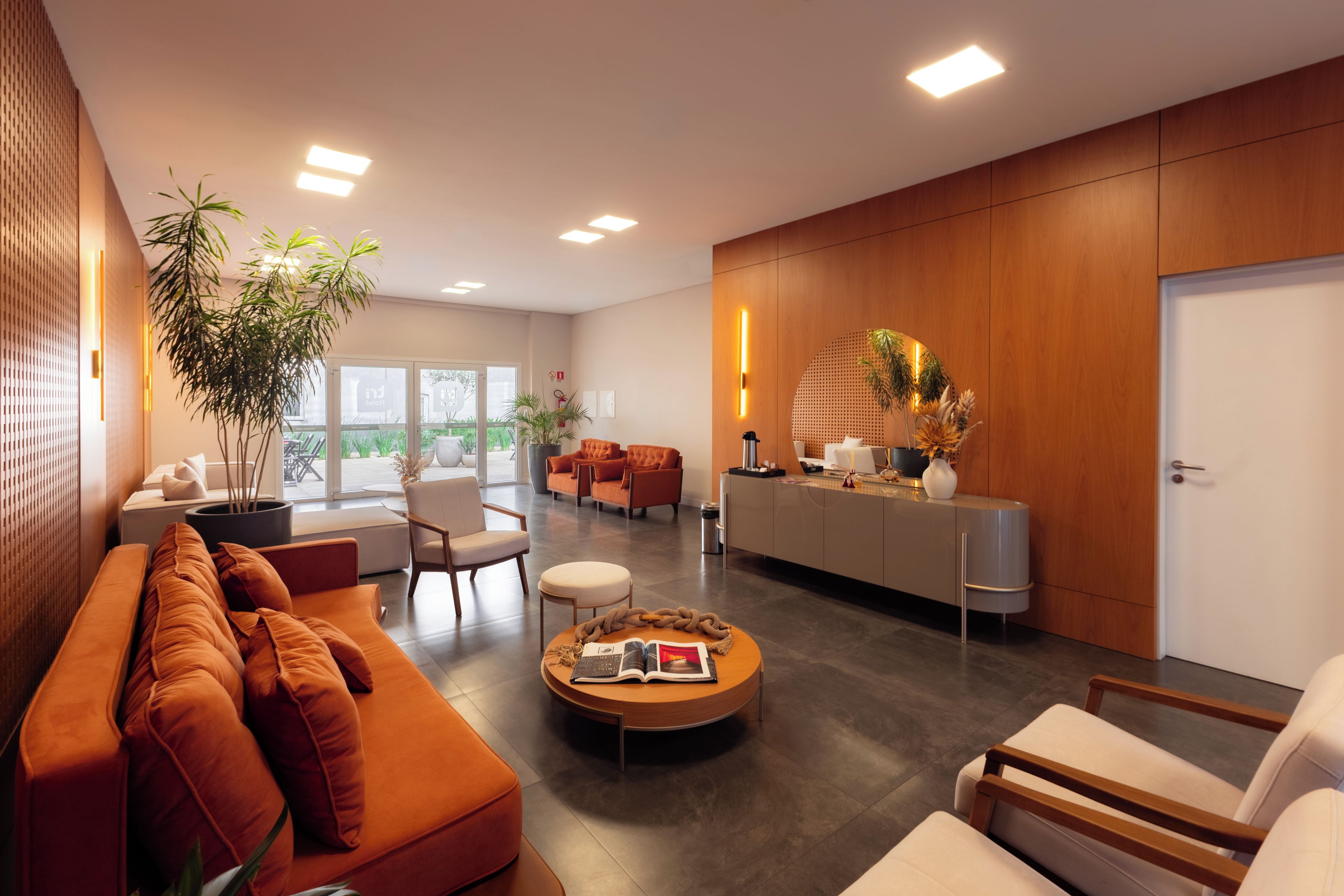 Uma sala de estar moderna com sofá, cadeiras, mesa de centro e balcão de recepção.