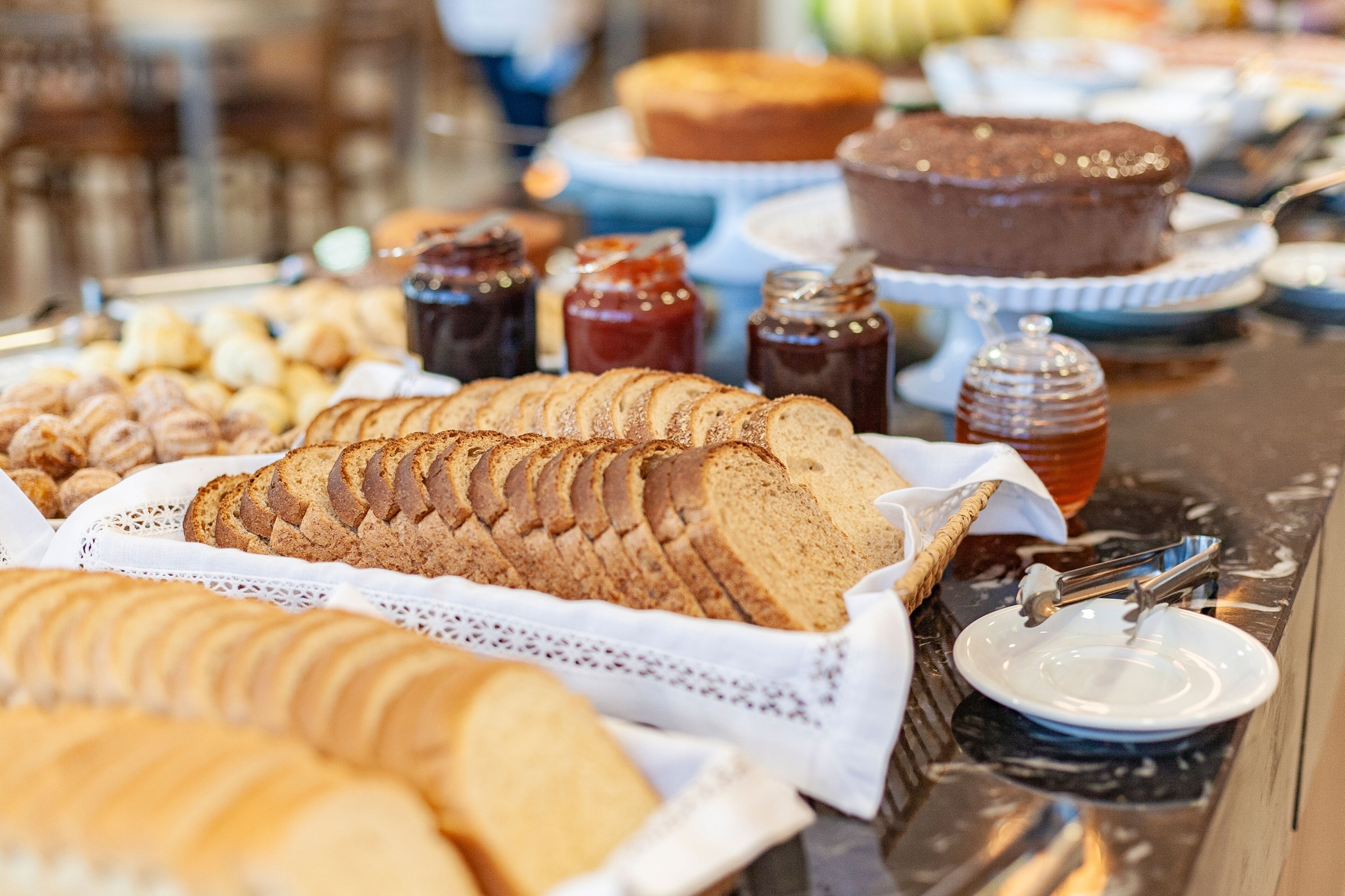 En buffet med forskellige brød, kager og desserter.