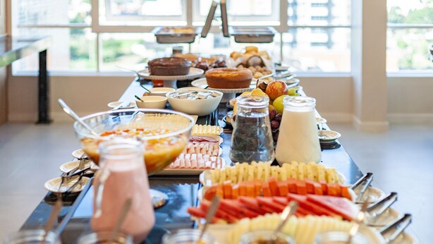 Una mesa de bufé con diversos alimentos y bebidas.