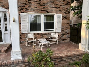A brick house with a porch, two white wicker chairs, and a small table. - Water Front Oasis 4 Bedroom Home by RedAwning (Norfolk)