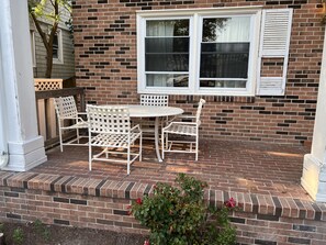 A patio with a brick wall, white shutters, and a white table and chairs. - Water Front Oasis 4 Bedroom Home by RedAwning (Norfolk)