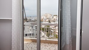 A view from a balcony with a terrazzo floor, overlooking a densely packed urban area with various buildings. - Modern apt with Increbilbe Athens Views (Galatsi)