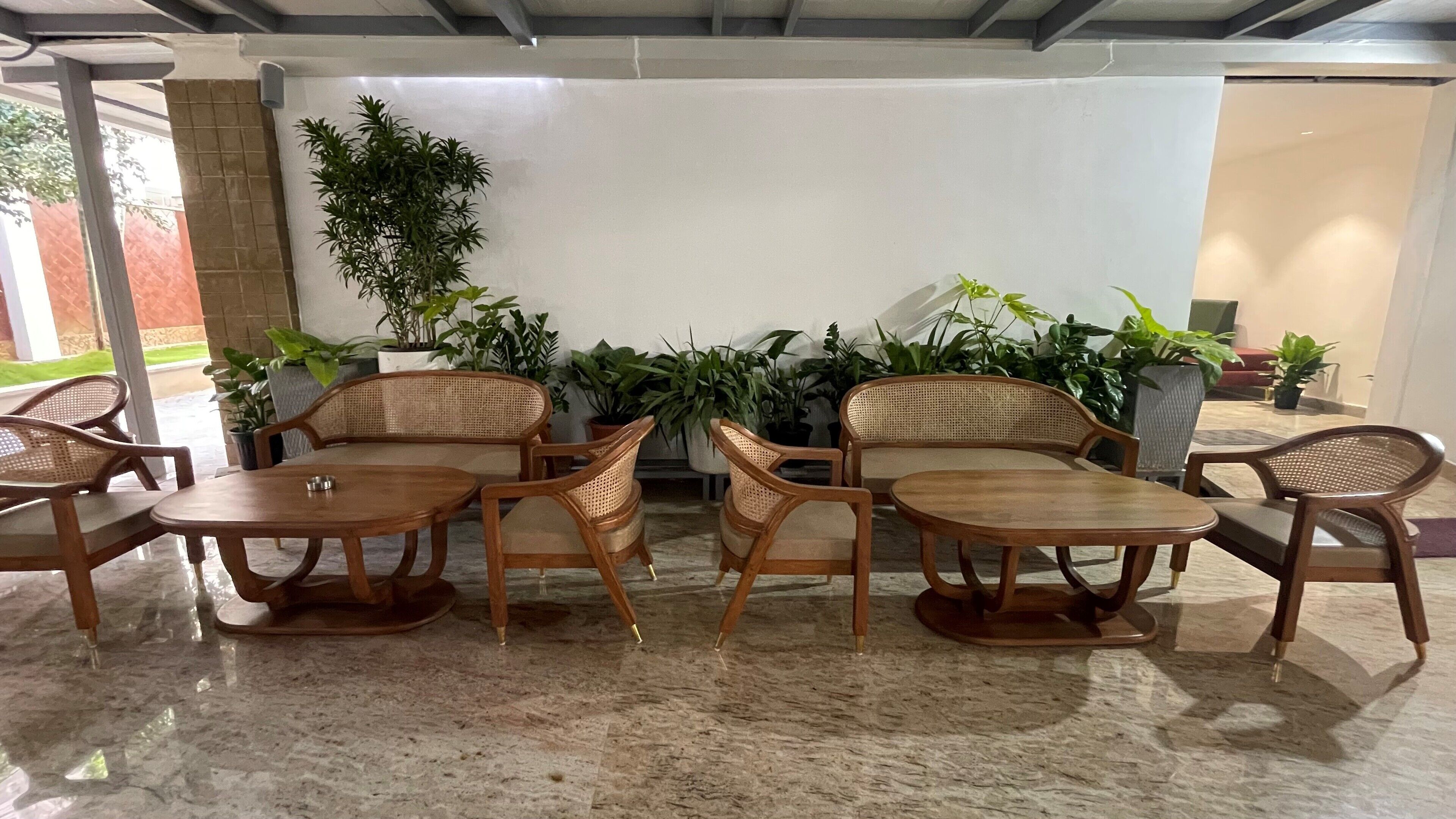 Un rincón con asientos de mimbre y plantas en macetas.