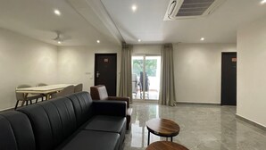 A modern hotel lobby with a sofa, a small table, and a dining area. - Hotel Silver Clé Hitech City (Hyderabad)