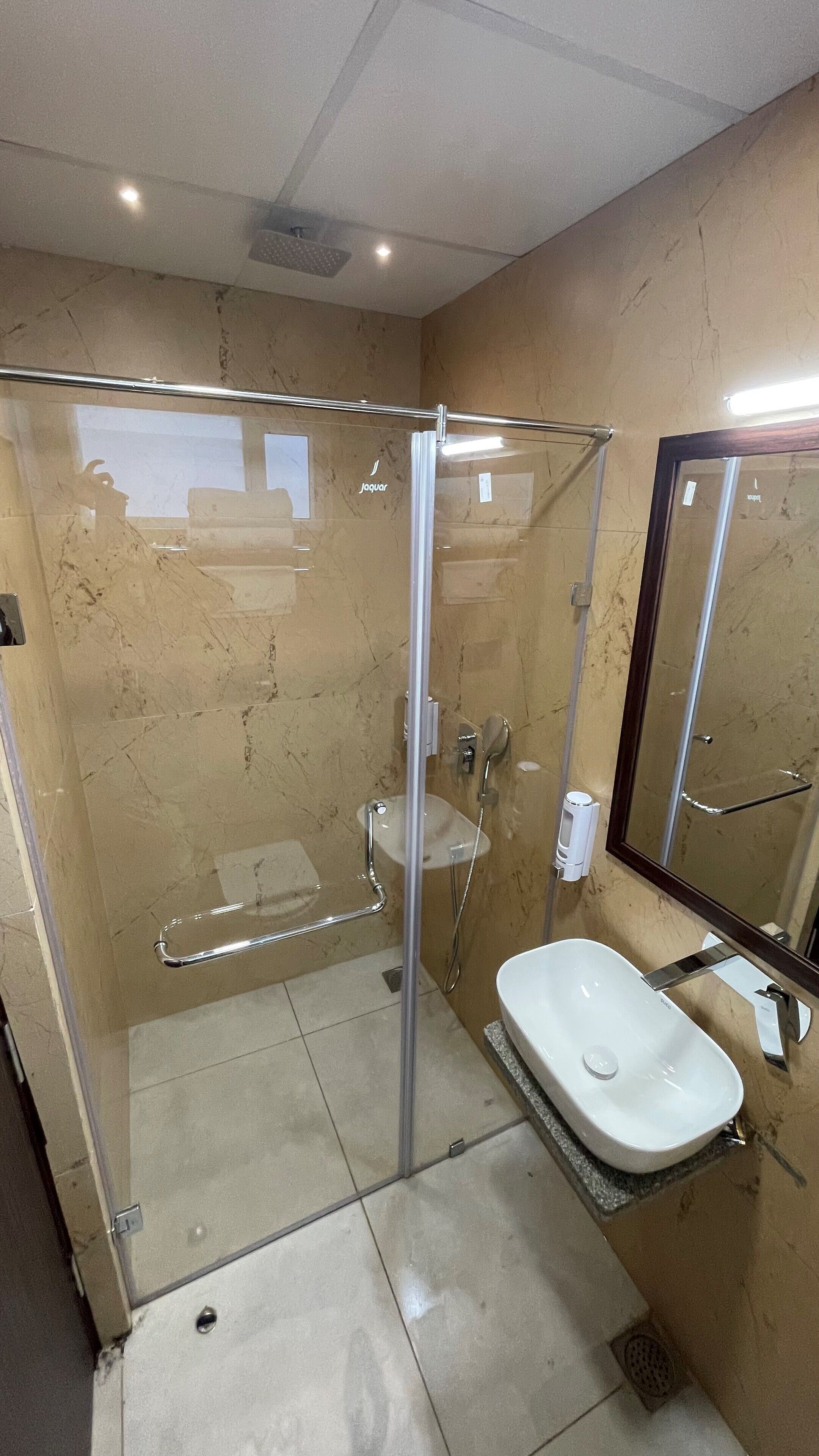A glass-enclosed shower with a white sink and a mirror.