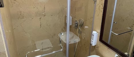 A glass-enclosed shower with a white sink and a mirror.