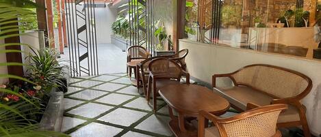 A reception area with a check-in counter, wooden furniture, and potted plants.