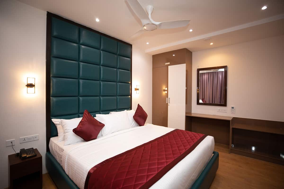 Une chambre d’hôtel moderne dotée d’un grand lit, d’un ventilateur de plafond et d’un bureau intégré.