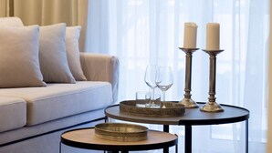 Un salon moderne avec un canapé, une table basse ronde et une petite table d’appoint.