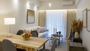 Una sala moderna con un sofá, una mesa de comedor y un frutero.