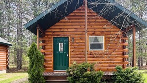 A log cabin with a green door, a small porch, and a sign reading "Leekery". - Log Cabin with Hot Tub 2 Miles from Crystal Mountain!!! (Thompsonville)