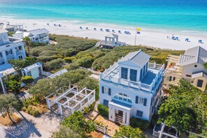 A coastal property with a beach view, multiple buildings, and a gazebo. - Beachfront in Seaside on 2 lots, Gulf views, Porches & Rooftop Deck, 2 Bikes (Santa Rosa Beach Fl)