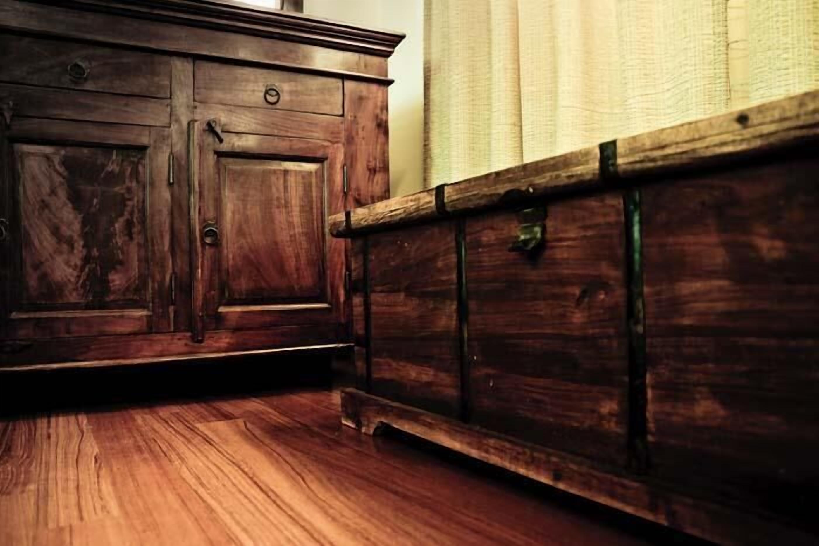 Un meuble en bois doté de plusieurs tiroirs et d’un banc en bois.