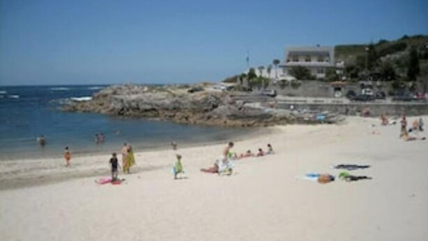A beach with people and boats.