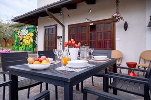 Een terras met een eettafel voor twee personen, omringd door stoelen.