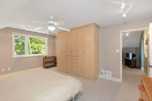 A bedroom with a bed, wardrobe, ceiling fan, and a window. - Panorama Cottage - perfect sunsets! (Parry Sound)
