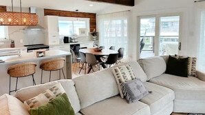 Una sala de estar moderna con un sofá, una mesa de comedor y una zona de cocina.