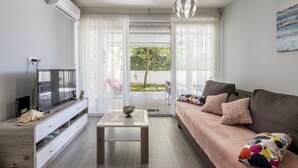 Ein modernes Wohnzimmer mit einer Couch, einem Fernseher und einem Tisch.