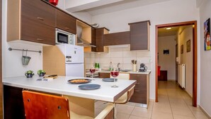 Una cocina moderna con una isla central, armarios blancos y un refrigerador de acero inoxidable.