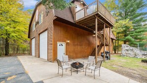 Een vakantiehuis in blokhutstijl met garage, terras en vuurplaats.