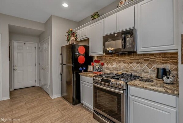 Enjoy cooking in this well-equipped kitchen with a refrigerator, oven, microwave, and gas stove.