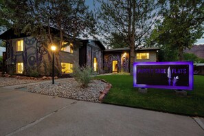 Ein modernes Haus mit einem Schild, auf dem „Purple Sage Flats“ steht.