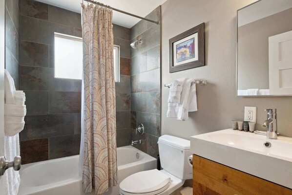 A bathroom with a bathtub, toilet, and sink. - Fire Pit Evenings • Hot Tub • Central Moab • BBQ (Moab)