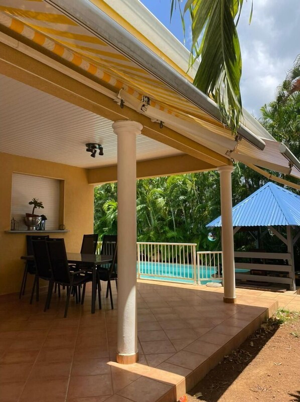 Relax by the pool in a tranquil outdoor space with a dining area and kitchenette.