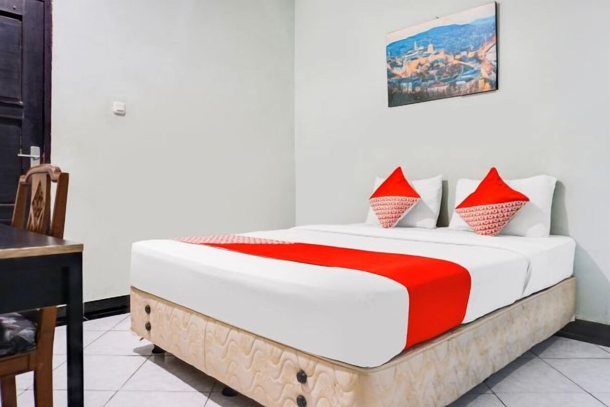 A hotel room with a bed, a dining table, and chairs.