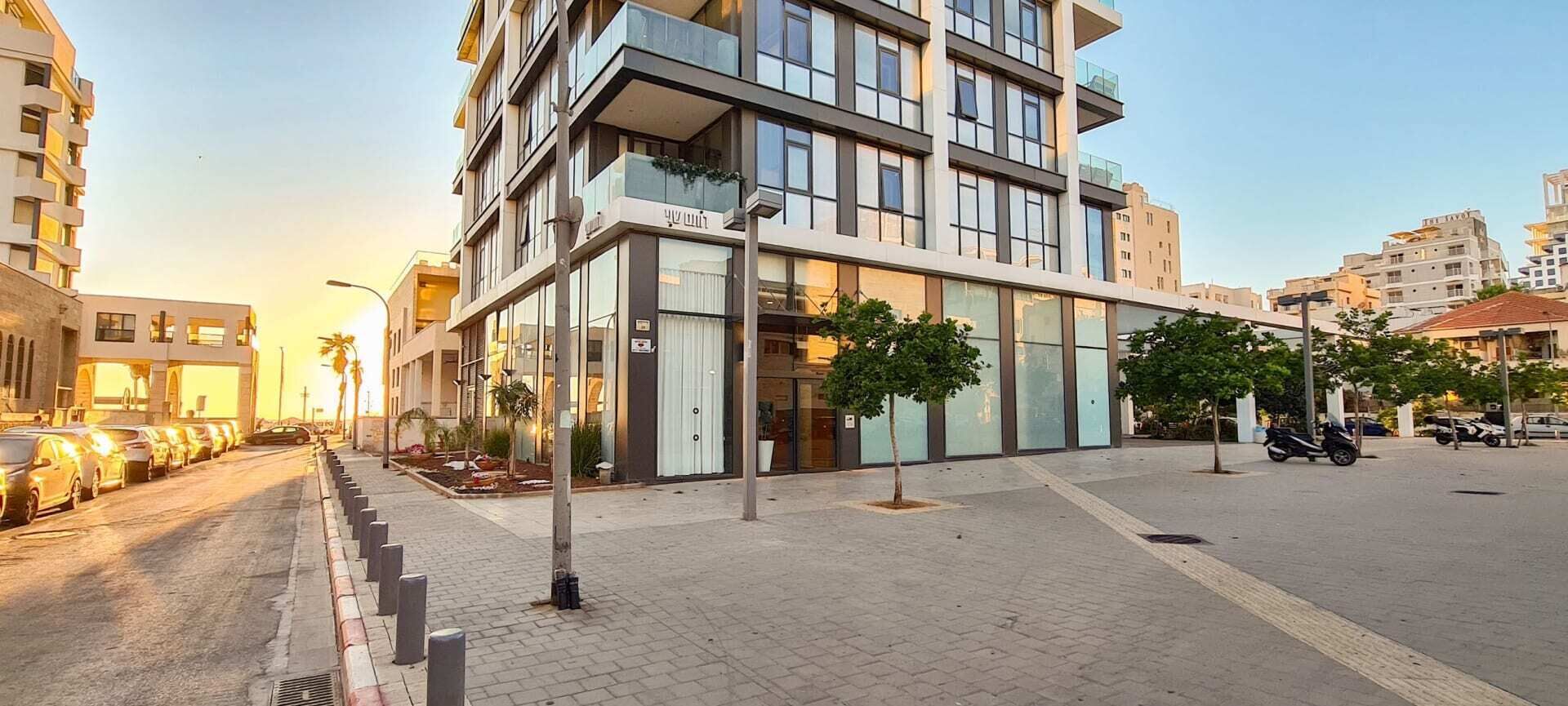 A modern multi-story building with large windows and a flat roof.