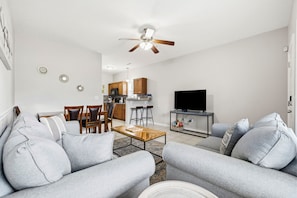 A living room with a sofa, coffee table, TV, and a ceiling fan. - 2 Bed, 2 Bath Coral Cottage—Walk to the Beach! (Myrtle Beach)